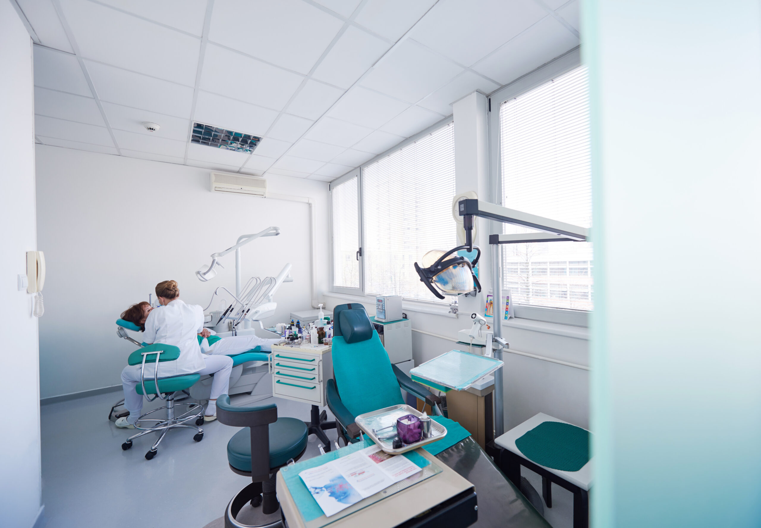 dental room with a dentist and patient in a chair having dental work done